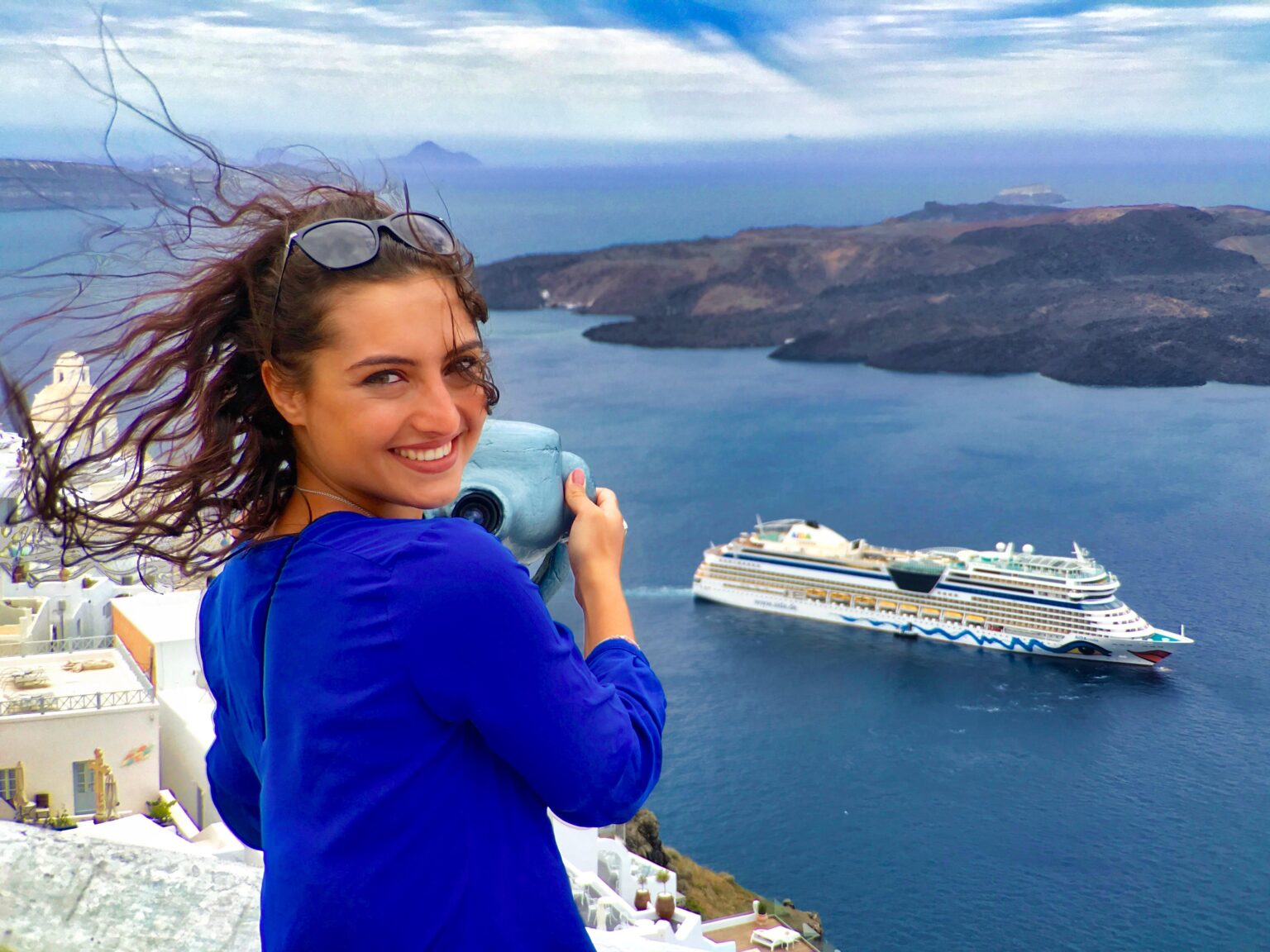 Reisende auf Santorin blickt auf ein Kreuzfahrtschiff in der Caldera
